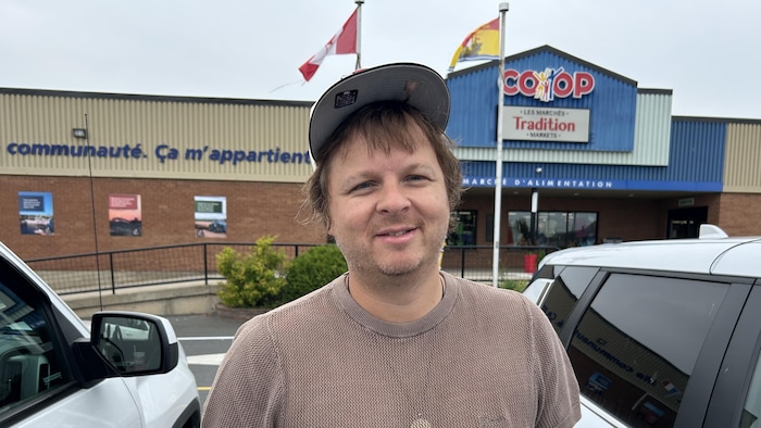 Un homme photographié devant la coop.