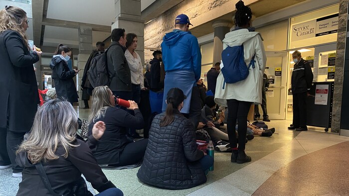 People camp in line outside a Service Canada passport office in Vancouver on Wednesday. Long lines and wait times are the result of a massive backlog of applications at passport offices across the country.