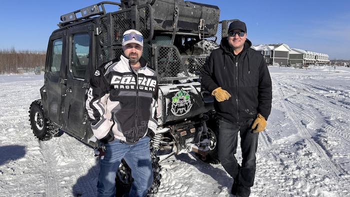 Deux hommes devant un véhicule tout-terrain à Fort McMurray.