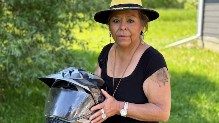 Marilyn Courchene pose avec un casque dans ses mains.