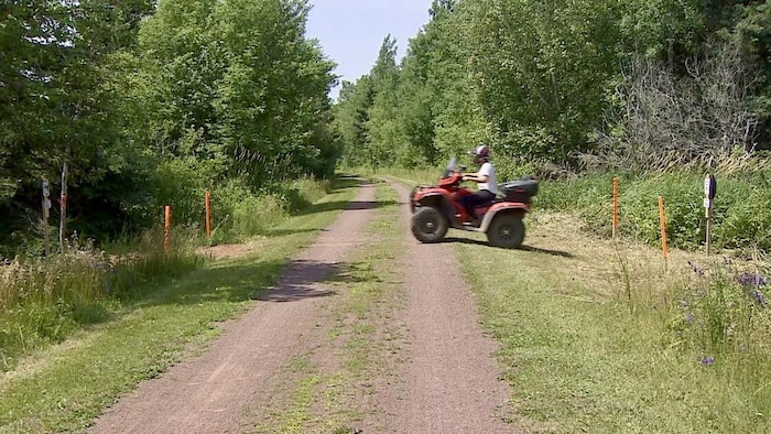 Une personne conduisant un véhicule tout-terrain traverse un sentier.