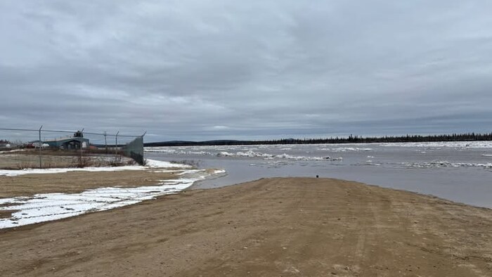 Une route de terre dont une partie est recouverte d'eau.