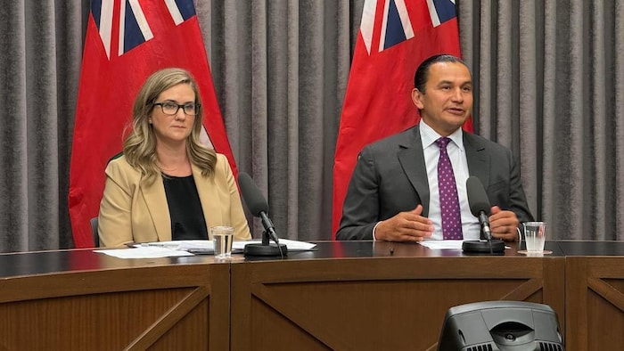 Wab Kinew et une femme assise à une table