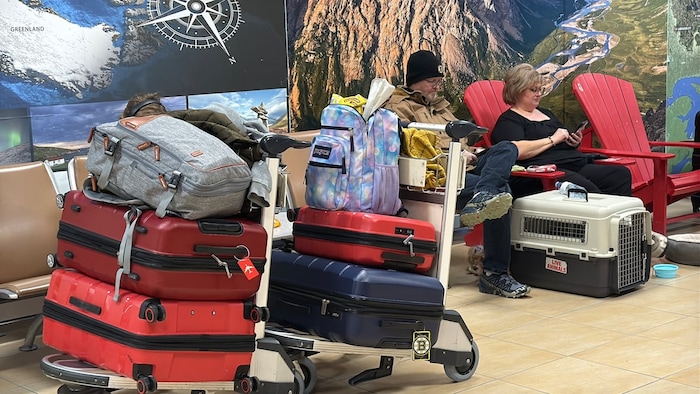 Des passagers avec leurs valises attendent leur vol à Wabush.