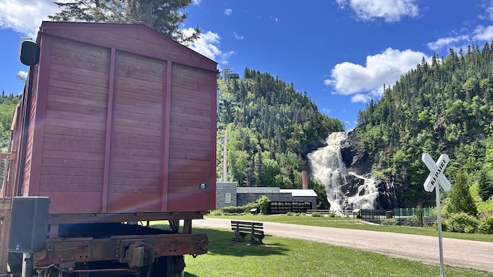 Un wagon de train devant des chutes