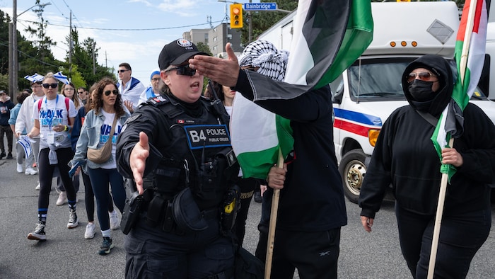 Des manifestants pro-Palestine, un policier et des participants à la marche.