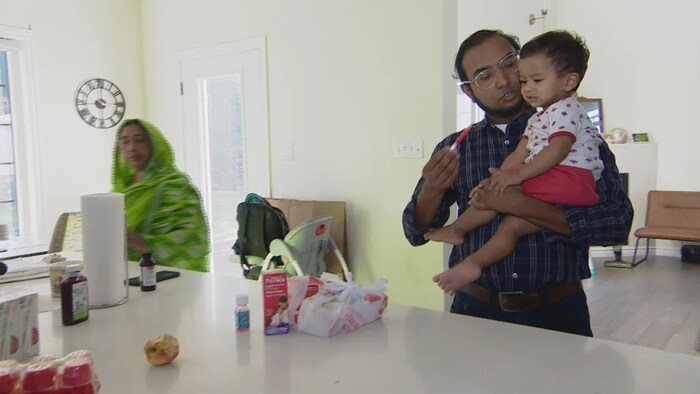 Washim Ahmed porte son enfant dans ses bras