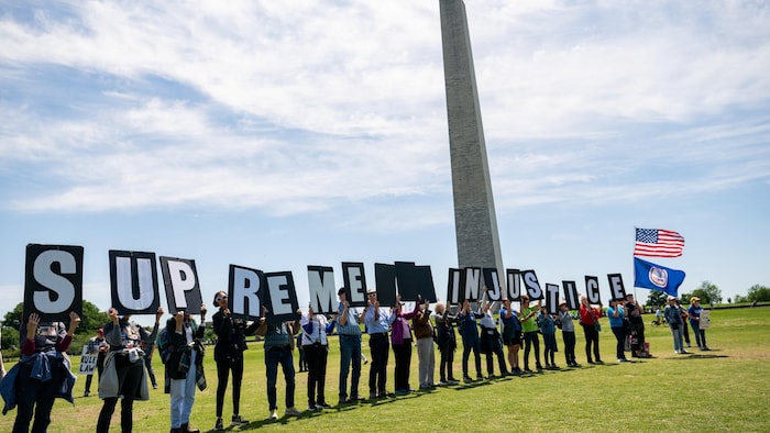 Des manifestants participent à un rassemblement devant le monument Washington.