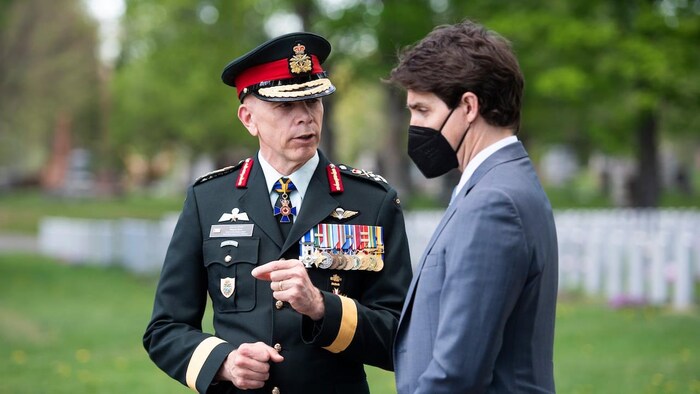 Chief of the Defence Staff Gen. Wayne Eyre speaks with Prime Minister Justin Trudeau before a ceremony at the National Military Cemetery in Ottawa on May 13, 2022.