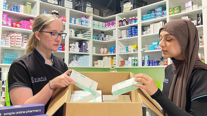 Deux femmes sortent des médicaments d'une boîte.
