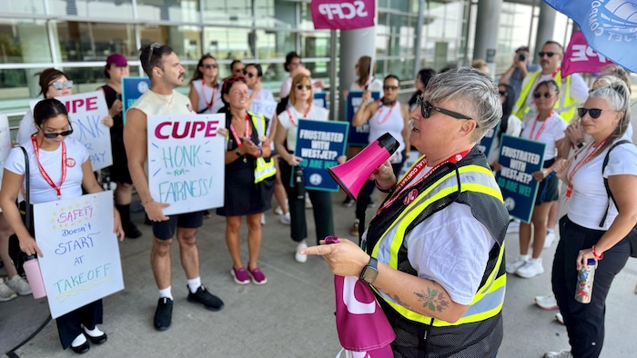 La présidente du SCFP Manitoba, Gina McKay, avec un mégaphone.