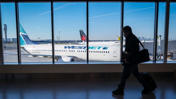 A passenger walks past Air Canada and WestJet planes at the Calgary International Airport in this file photo from August 2022. So far in 2025, travel to and from the U.S. is down, but not as much as at other airports in Canada.