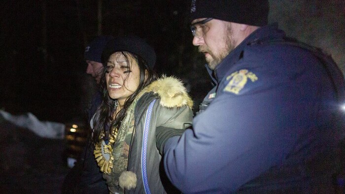 الشرطة الملكية الكندية توقف متظاهرة في مخيم تأييد للزعماء الوراثيين لأمّة ’’وتسُويتن‘‘ (Wet’suwet’en) من السكان الأصليين المعترضين على توسيع أنبوب ’’ترلانس ماونتن‘‘، في بريتيش كولومبيا في كانون الثاني (يناير) 2020.