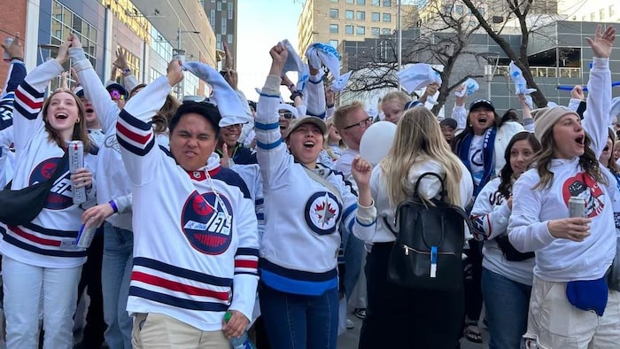 Des personnes vêtues du chandail des Jets de Winnipeg, le 21 avril 2024.