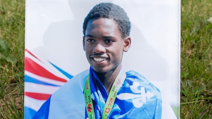 Une photo d'un jeune portant une médaille d'or au cou.