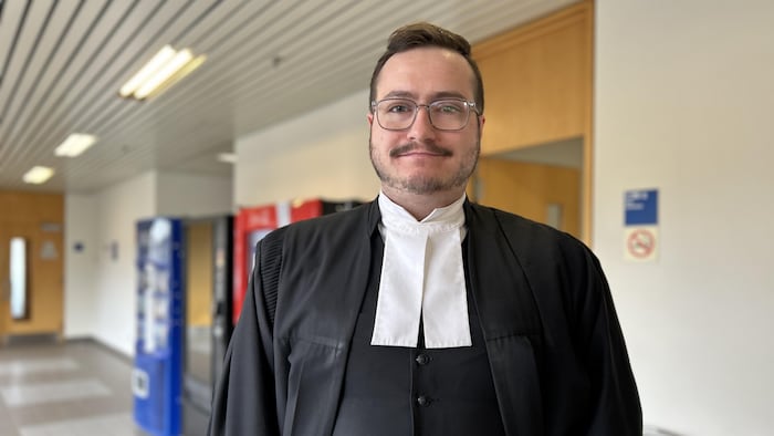 Un avocat debout dans le corridor d'un palais de justice.