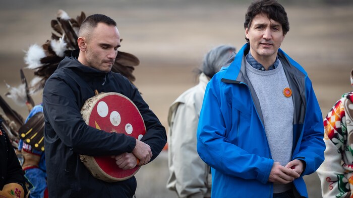 Willie Sellars sostiene un tambor en su contra junto a Justin Trudeau.