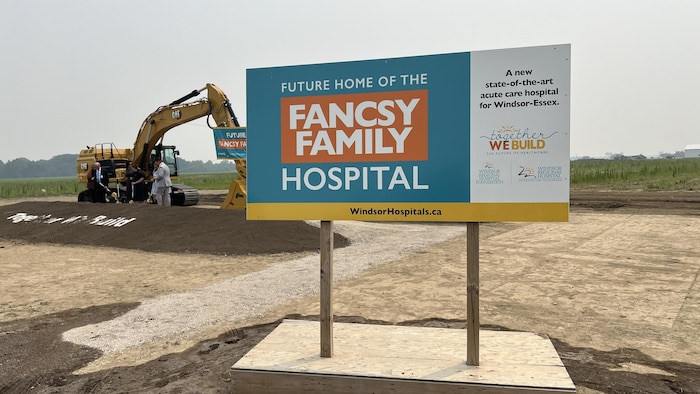 Un panneau indiquant la construction de l'hôpital Fancsy, avec une grue en arrière plan.
