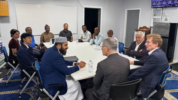 Des personnes assises autour d'une table. 