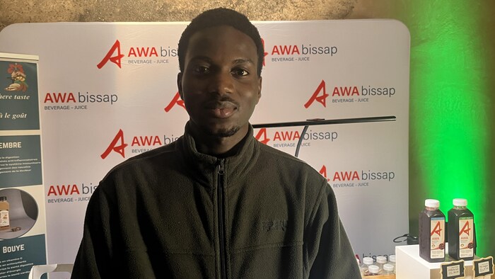 Mouhamed Soumbounou est debout devant une pancarte le 8 février 2026 à Winnipeg.