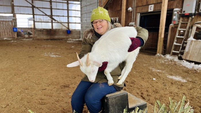 Louise May, assise avec une chèvre.
