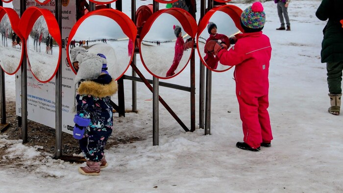 Deux enfants se regardant dans les miroirs convexes de l’installation « Chimera ».