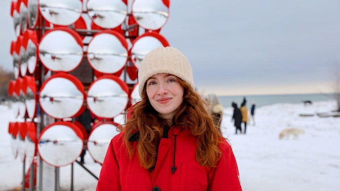 Katarina Prystray, coorganisatrice de l’édition 2026 du Winter Stations de Toronto, devant l’installation « Chimera », où plusieurs miroirs bombés ont été installés sur les quatre côtés d’une chaise de sauveteur sur une plage du lac Ontario.