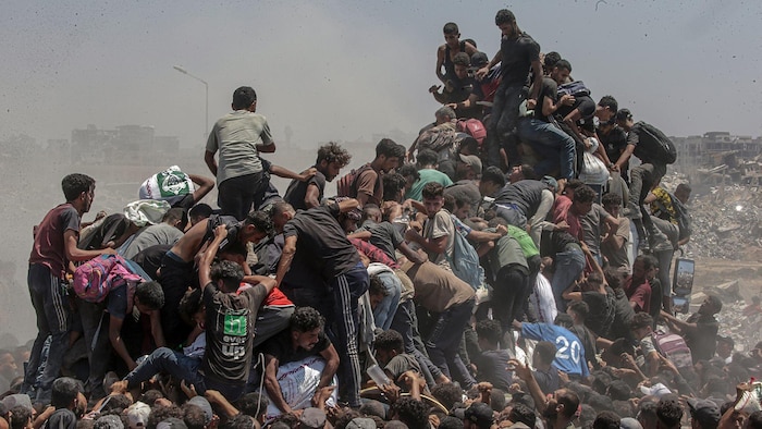 Une foule d'hommes affamés grimpe sur un camion à Gaza.
