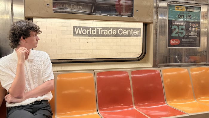 Un jeune homme assis dans le métro, dans la station du World Trade Center.