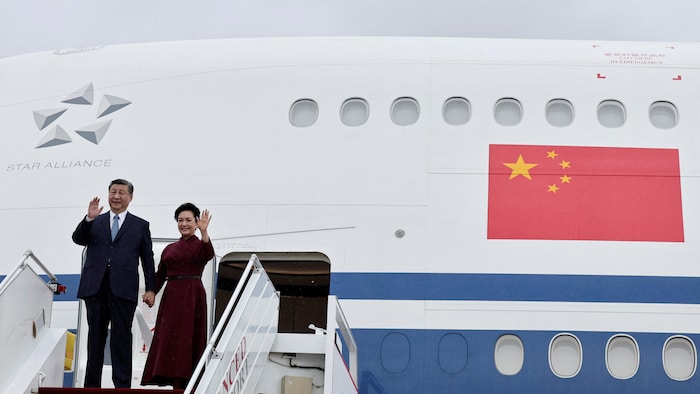 Xi Jinping et sa femme dont un salut de la main à leur sortie de l'avion.