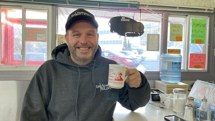 Yan Gélineau, un café à la main.