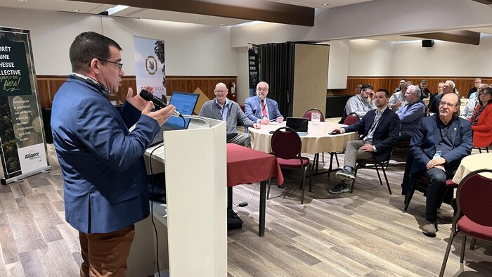 Le président de l'Alliance forêt boréale fait un discours devant une salle comble.