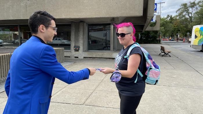 Un homme donnant un tract à une femme.