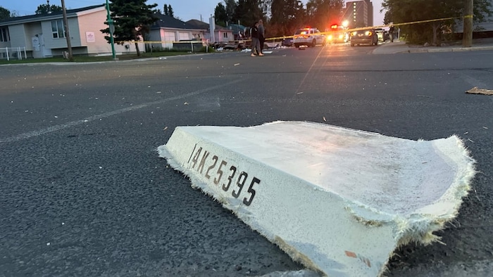 Un débris potentiel de bateau par terre au milieu de la rue.