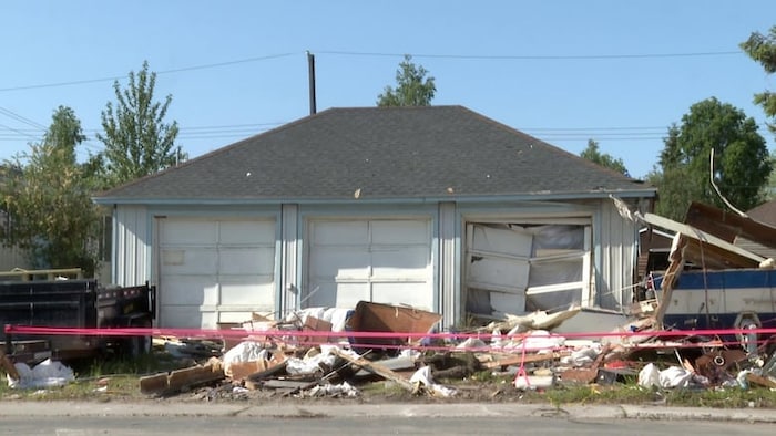 Des débris des suites de l'explosion entourent un bâtiment.