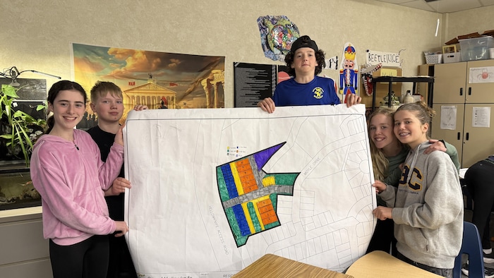 Une groupe d'élèves tenant une carte colorée.