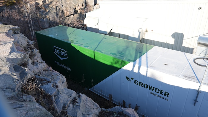 Un long conteneur vert et blanc, sur lequel est écrit Co-op Yellowknife et Growcer.