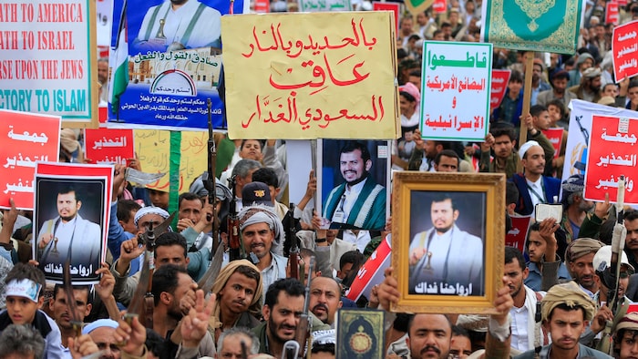 Des manifestants brandissant des portraits et des pancartes.