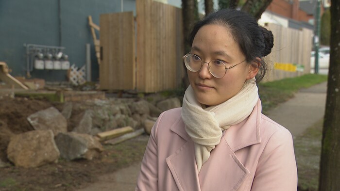 Yi Ariel Liu est devant la garderie. Derrière elle, la clôture brisée là où l'accident a eu lieu.
