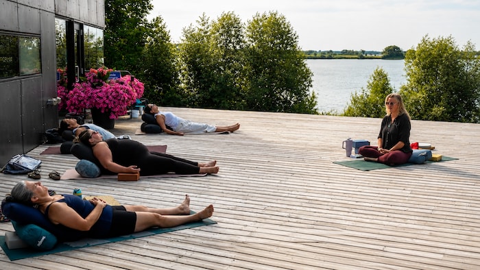 Des personnes pratiquent le yoga au bord de la riviere Winnipeg