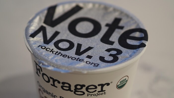 Un message incitant les gens à aller voter le 3 novembre bien en évidence sur un pot de yogourt.