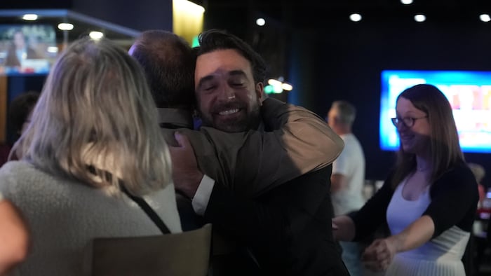 Yohann St-Pierre faite une accolade à un homme lors de sa victoire comme député pour le Parti québécois. 