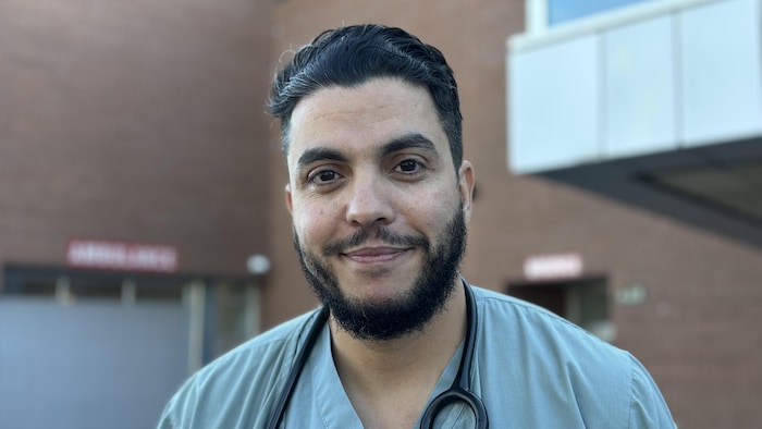 Une personne pose devant la caméra.