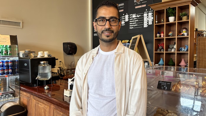 Un homme devant son comptoir.