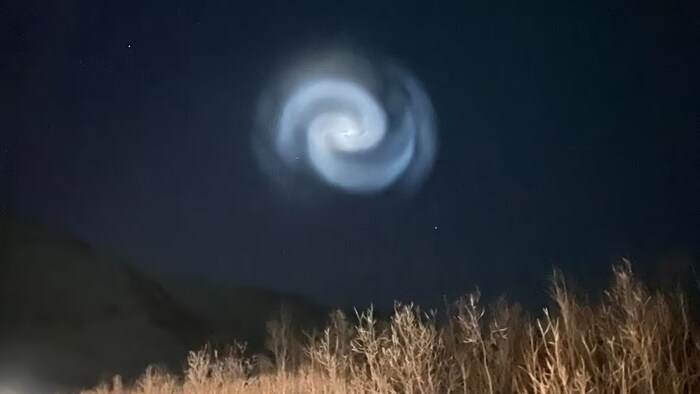 Une spirale de lumière dans le ciel nocturne. 