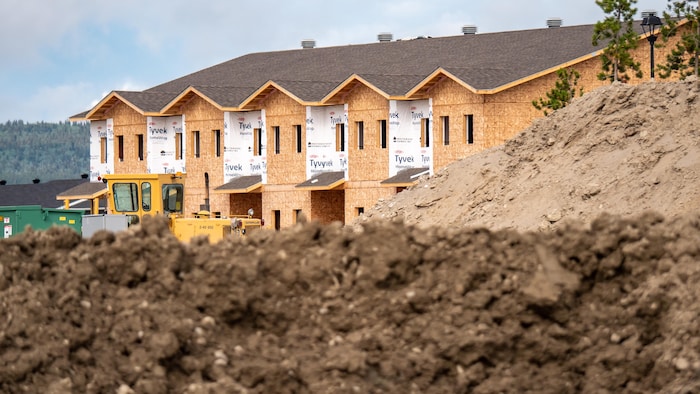 Des maisons en construction avec de la terre au premier plan.