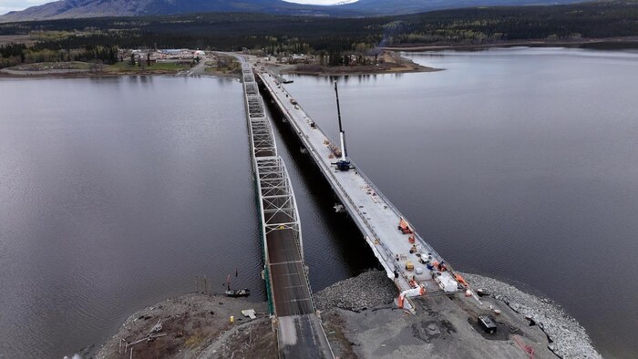 Une vue aérienne d'un chantier de construction du nouveau pont Nisutlin de Teslin, au Yukon, à côté de l'ancien pont, le 22 mai 2025.