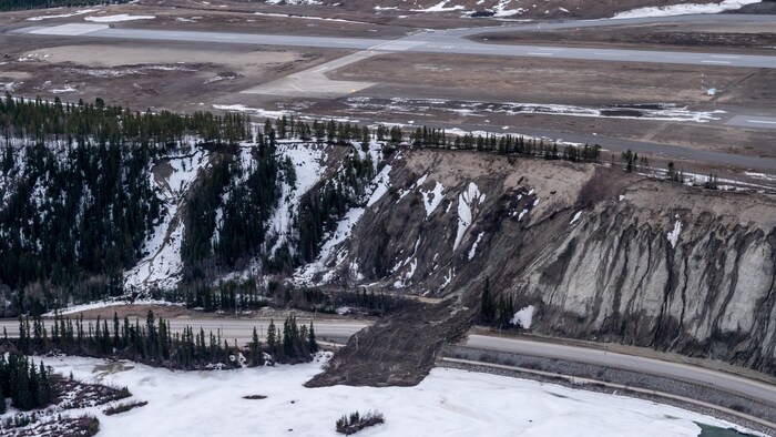 On peut voir des débris d'un glissement de terrain survenu le 30 avril 2022 à Whitehorse, bloquant la route Robert-Service et se déversant sur le fleuve Yukon.