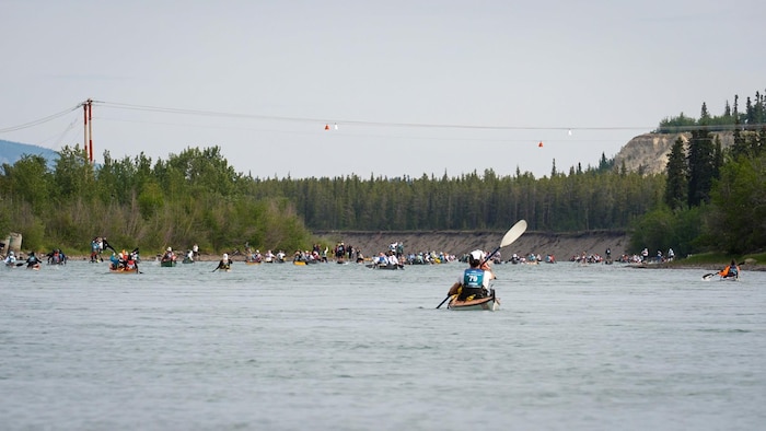 Plusieurs personnes sur des embarcations sur le fleuve Yukon, le 25 juin 2025. 
