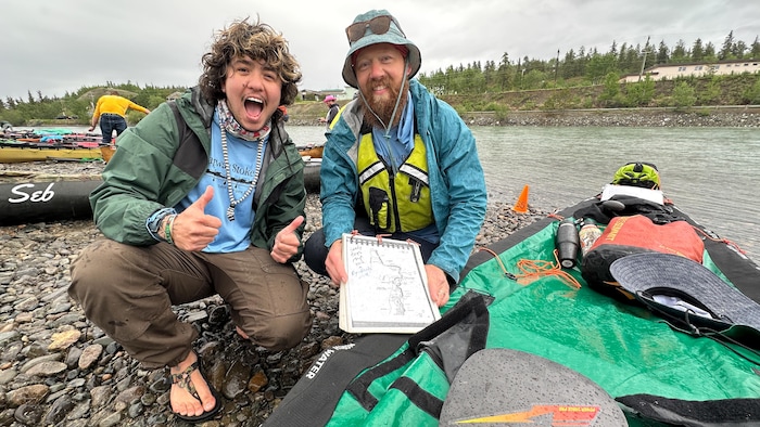Christian Nunez et Jon Hillis posent devant un canot.